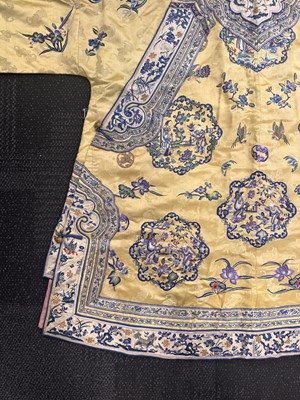 Lot 395 - A fine Chinese yellow-ground embroidered silk robe, Qing dynasty, 19th Century
