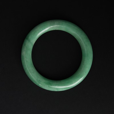 Lot 582 - A Chinese green jade bangle