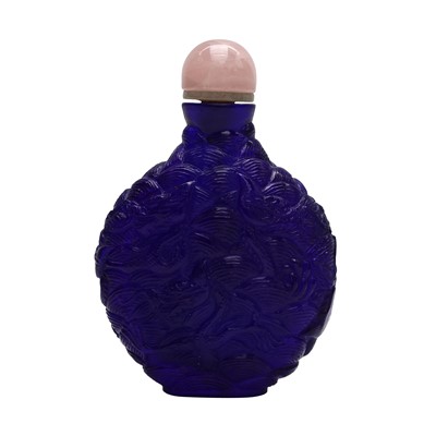 Lot 740 - A Chinese carved purple glass 'waves' snuff bottle, 19th century