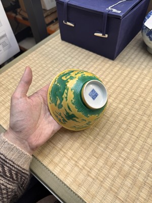 Lot 62 - A Chinese green-enamelled yellow-ground 'dragon' bowl, Qianlong mark and possibly of the period