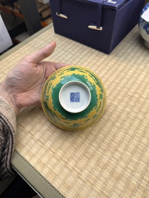 Lot 62 - A Chinese green-enamelled yellow-ground 'dragon' bowl, Qianlong mark and possibly of the period
