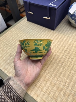 Lot 62 - A Chinese green-enamelled yellow-ground 'dragon' bowl, Qianlong mark and possibly of the period