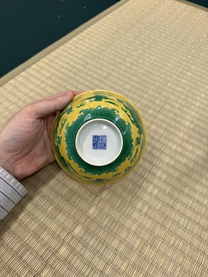 Lot 62 - A Chinese green-enamelled yellow-ground 'dragon' bowl, Qianlong mark and possibly of the period