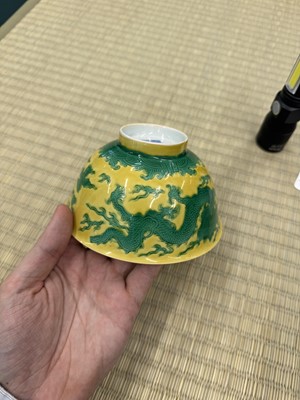 Lot 62 - A Chinese green-enamelled yellow-ground 'dragon' bowl, Qianlong mark and possibly of the period