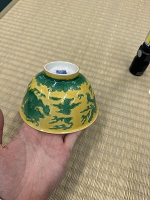 Lot 62 - A Chinese green-enamelled yellow-ground 'dragon' bowl, Qianlong mark and possibly of the period