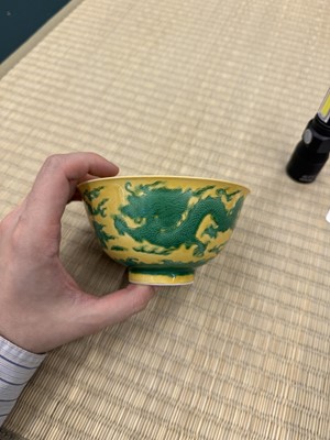 Lot 62 - A Chinese green-enamelled yellow-ground 'dragon' bowl, Qianlong mark and possibly of the period