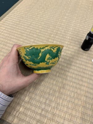 Lot 62 - A Chinese green-enamelled yellow-ground 'dragon' bowl, Qianlong mark and possibly of the period