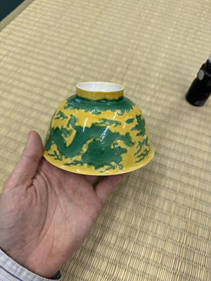 Lot 62 - A Chinese green-enamelled yellow-ground 'dragon' bowl, Qianlong mark and possibly of the period