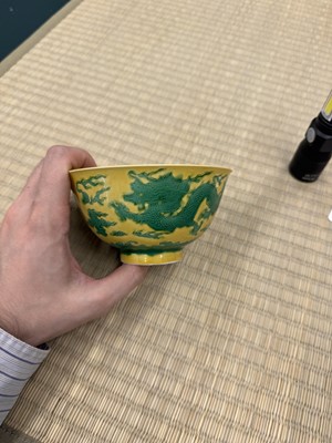 Lot 62 - A Chinese green-enamelled yellow-ground 'dragon' bowl, Qianlong mark and possibly of the period