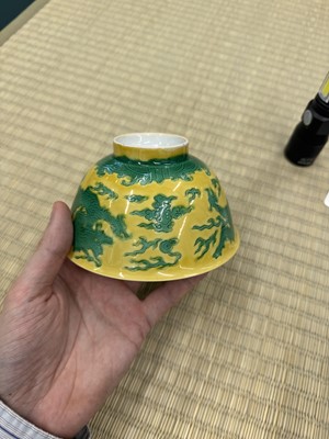 Lot 62 - A Chinese green-enamelled yellow-ground 'dragon' bowl, Qianlong mark and possibly of the period