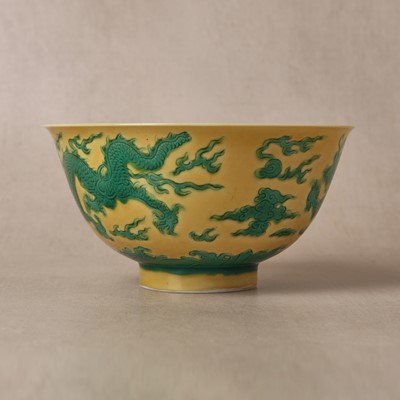 Lot 62 - A Chinese green-enamelled yellow-ground 'dragon' bowl, Qianlong mark and possibly of the period