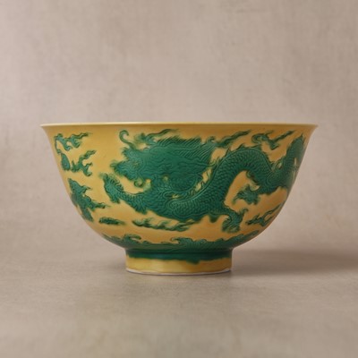 Lot 62 - A Chinese green-enamelled yellow-ground 'dragon' bowl, Qianlong mark and possibly of the period