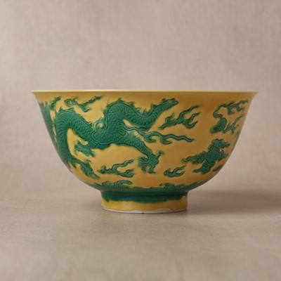 Lot 62 - A Chinese green-enamelled yellow-ground 'dragon' bowl, Qianlong mark and possibly of the period