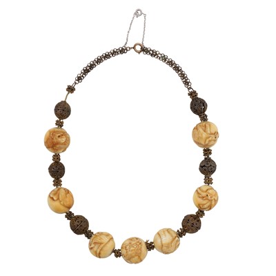 Lot 136 - A carved ivory bead necklace