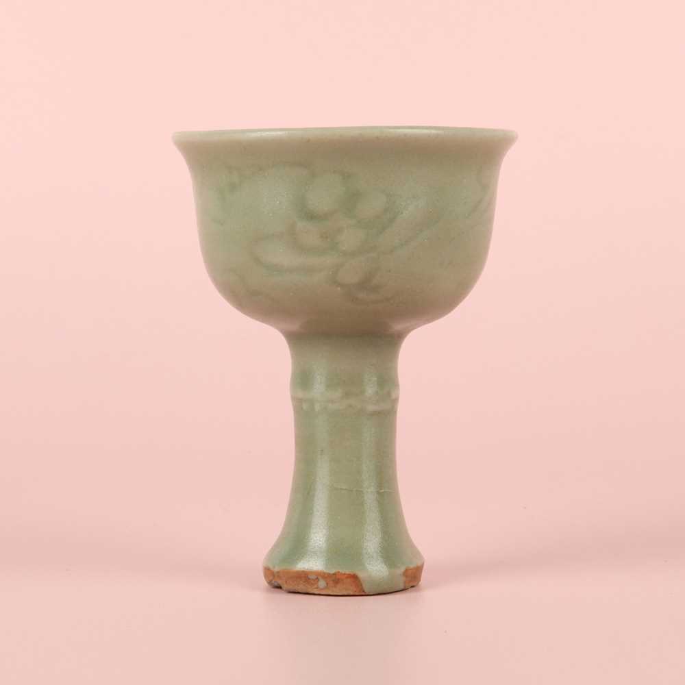 Lot 1 - A Chinese Longquan celadon 'floral' carved stem cup, Yuan - Early Ming dynasty