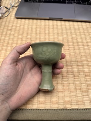 Lot 1 - A Chinese Longquan celadon 'floral' carved stem cup, Yuan - Early Ming dynasty