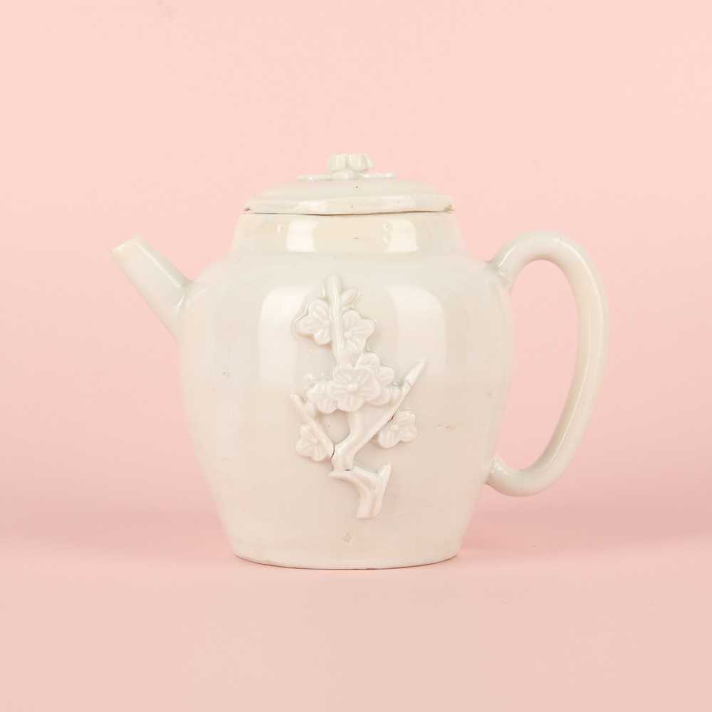 Lot 23 - A Chinese Dehua 'prunus' teapot and cover, Transitional - Qing dynasty, Shunzhi - Kangxi period