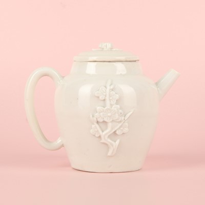 Lot 23 - A Chinese Dehua 'prunus' teapot and cover, Transitional - Qing dynasty, Shunzhi - Kangxi period