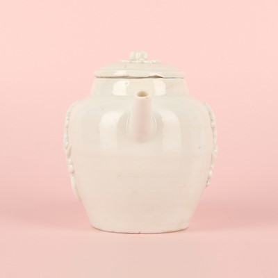 Lot 23 - A Chinese Dehua 'prunus' teapot and cover, Transitional - Qing dynasty, Shunzhi - Kangxi period