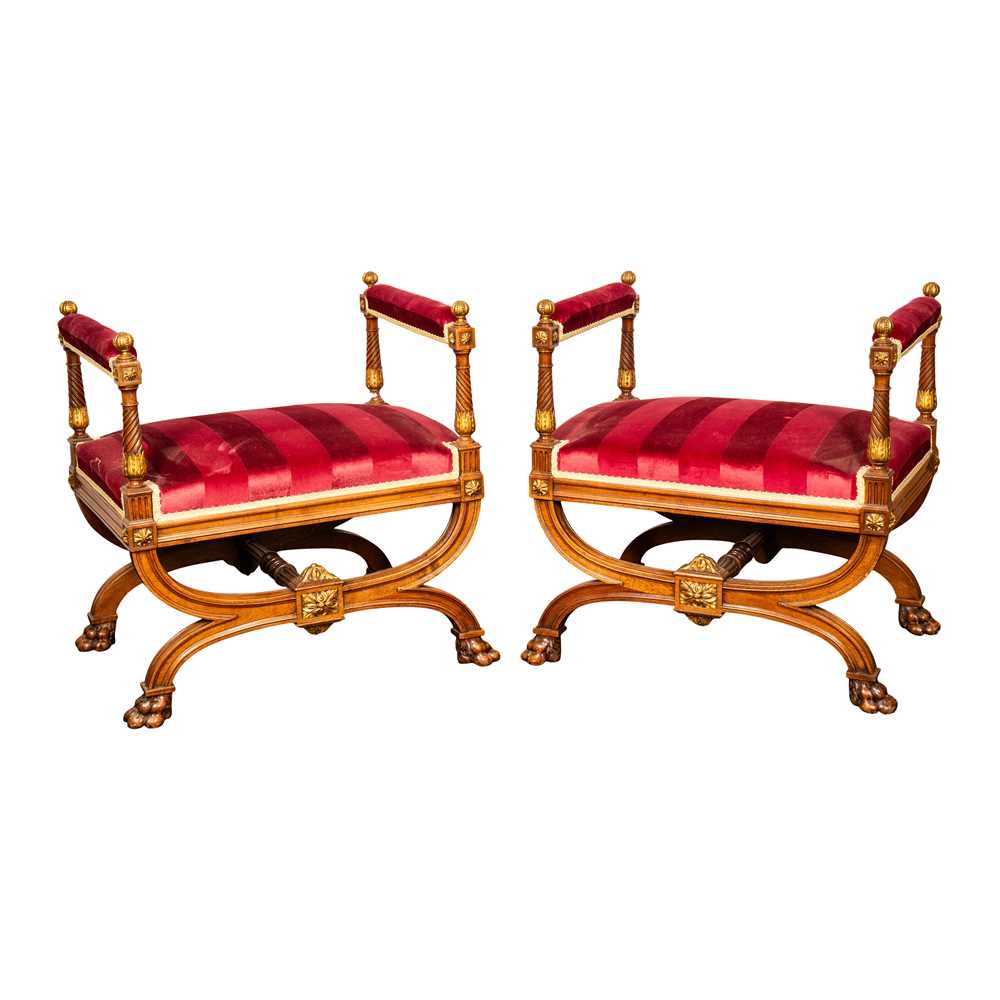 Lot 9 - A pair of French Empire walnut and parcel gilt X-frame stools