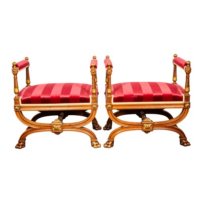 Lot 9 - A pair of French Empire walnut and parcel gilt X-frame stools