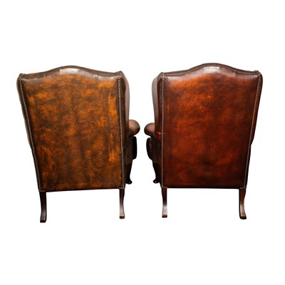 Lot 19 - A pair of brown leather wing back armchairs and stools