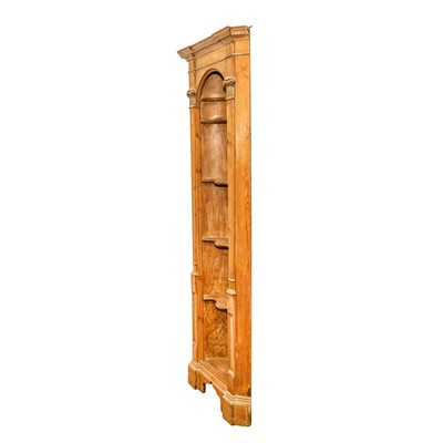 Lot 28 - A Neoclassical style limed pine corner niche bookcase of architectural form, 19th century