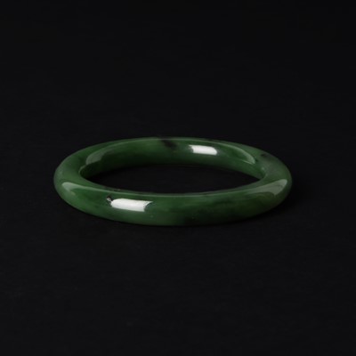 Lot 126 - A Chinese dark green jade bangle, 19th - 20th century
