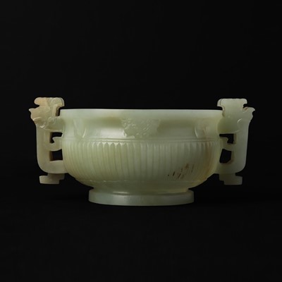 Lot 318 - A Chinese celadon jade archaistic twin-handled cup, Qing dynasty, 18th century