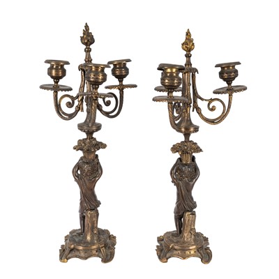 Lot 72 - A pair of French patinated bronze and ormulu three-light candeladra