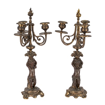 Lot 72 - A pair of French patinated bronze and ormulu three-light candeladra