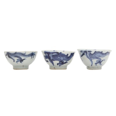 Lot 606 - Three Chinese blue and white 'dragon' cups, Qing dynasty, 18th/19th century