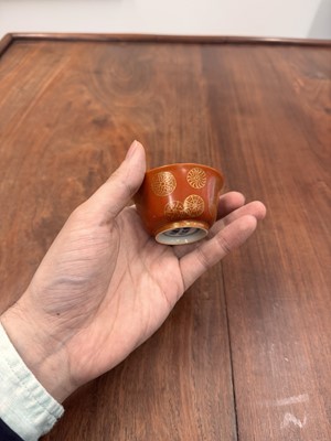 Lot 79 - A pair of Chinese coral-ground gilt-decorated cups, Qing dynasty, Yongzheng marks