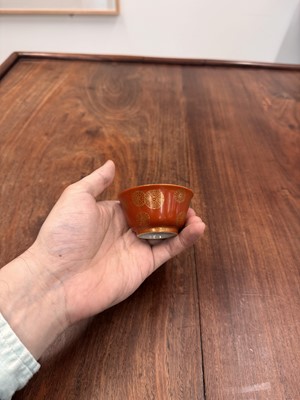Lot 79 - A pair of Chinese coral-ground gilt-decorated cups, Qing dynasty, Yongzheng marks