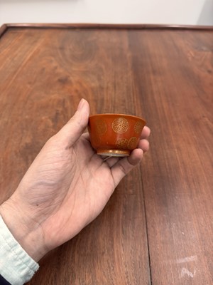 Lot 79 - A pair of Chinese coral-ground gilt-decorated cups, Qing dynasty, Yongzheng marks