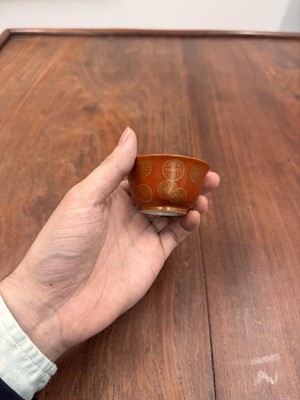 Lot 79 - A pair of Chinese coral-ground gilt-decorated cups, Qing dynasty, Yongzheng marks