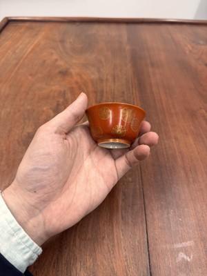 Lot 79 - A pair of Chinese coral-ground gilt-decorated cups, Qing dynasty, Yongzheng marks