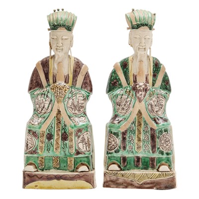 Lot 25 - A pair of Chinese sancai-glazed biscuit 'court official' figures, Qing dynasty, Kangxi period