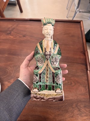 Lot 25 - A pair of Chinese sancai-glazed biscuit 'court official' figures, Qing dynasty, Kangxi period