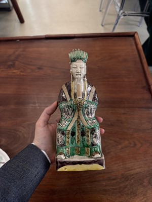 Lot 25 - A pair of Chinese sancai-glazed biscuit 'court official' figures, Qing dynasty, Kangxi period