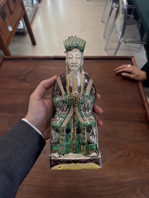 Lot 25 - A pair of Chinese sancai-glazed biscuit 'court official' figures, Qing dynasty, Kangxi period