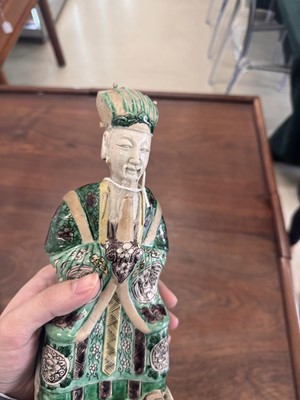 Lot 25 - A pair of Chinese sancai-glazed biscuit 'court official' figures, Qing dynasty, Kangxi period
