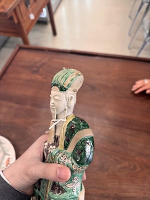 Lot 25 - A pair of Chinese sancai-glazed biscuit 'court official' figures, Qing dynasty, Kangxi period