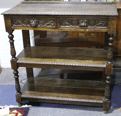 Lot 234 - An Edwardian carved oak unit with drawers over...