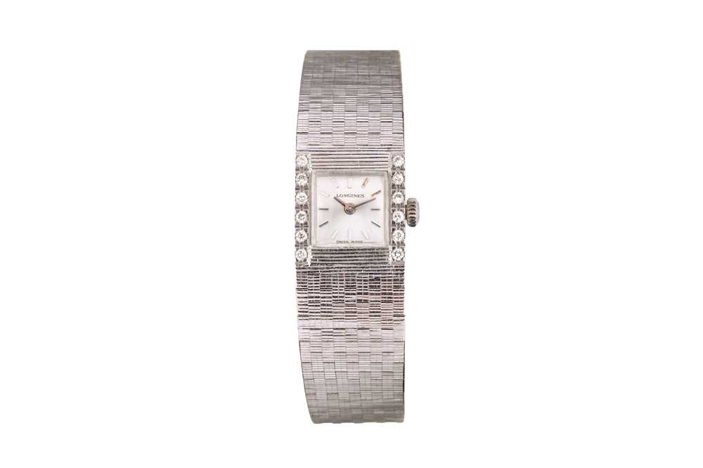 Lot 32 - LONGINES. AN 18K WHITE GOLD AND DIAMOND SET...