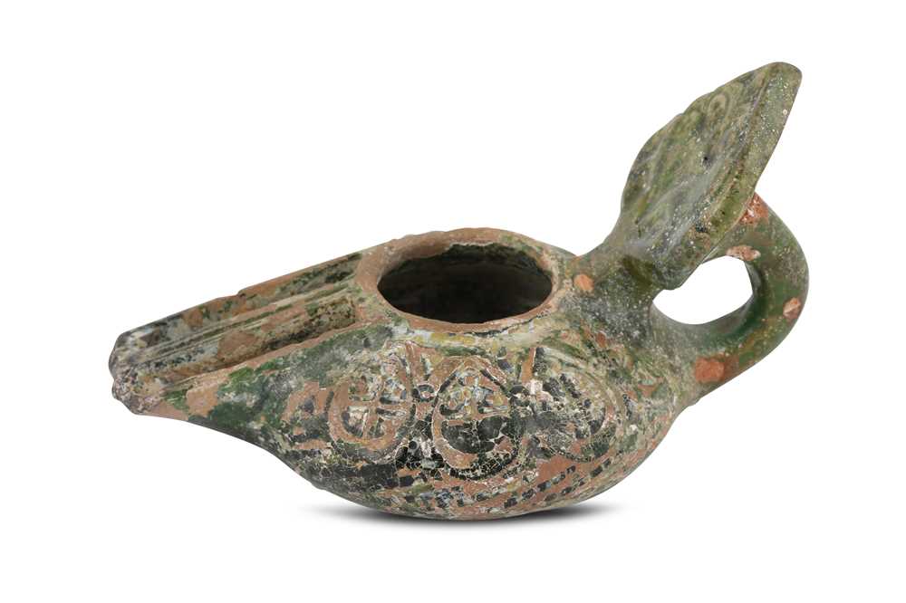 Lot 8 - AN EARLY GREEN-GLAZED POTTERY OIL LAMP...