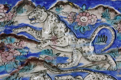 Lot 148 - A QAJAR MOULDED POTTERY TILE WITH LEOPARDS...