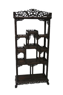 Lot 656 - A Chinese carved hardwood open display cabinet,...