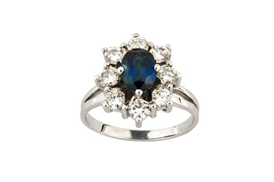 Lot 125 - A sapphire and diamond cluster ring Centrally...