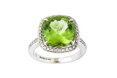 Lot 50 - A peridot and diamond cluster ring The cushion-...